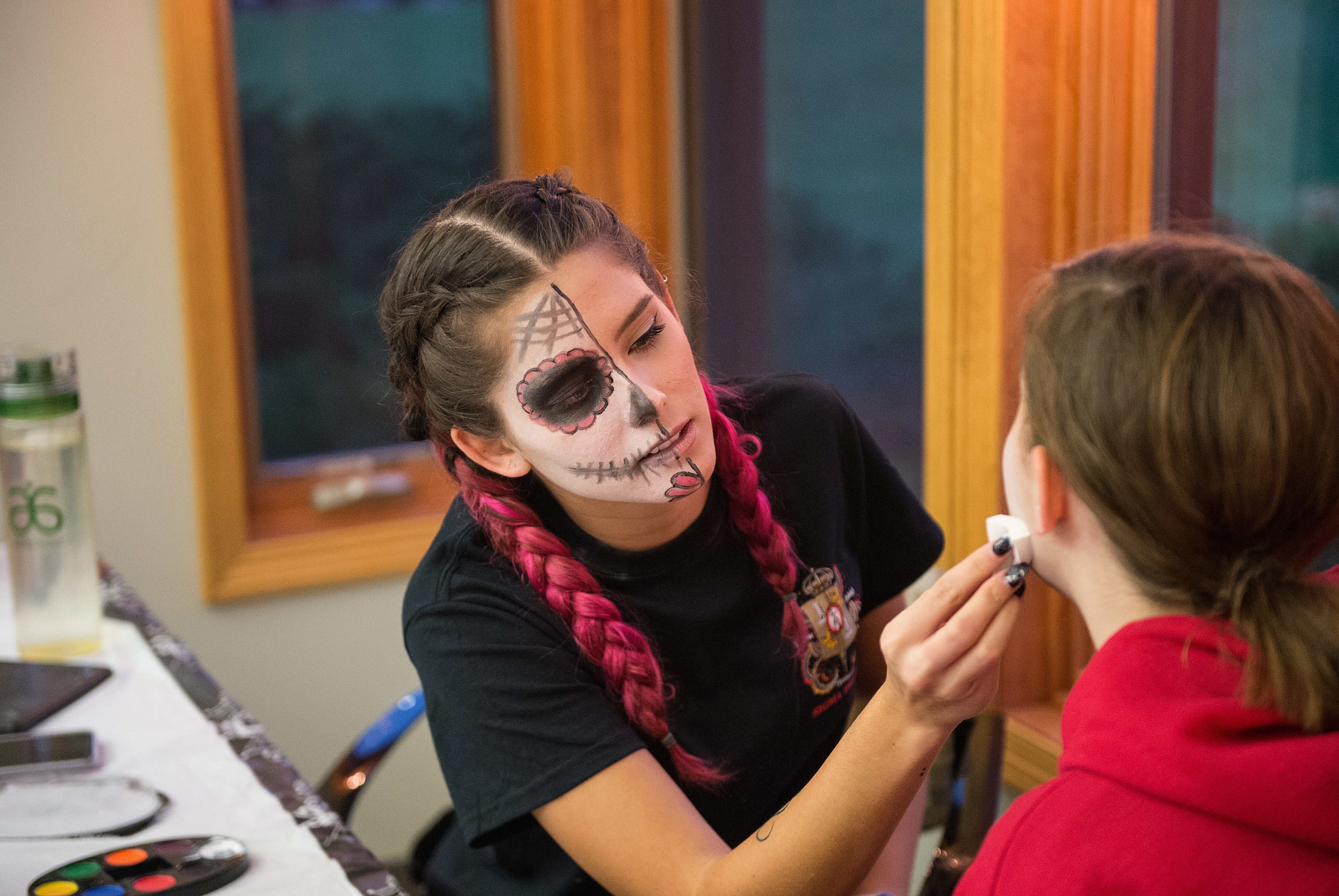 Student helping each other on makeup.