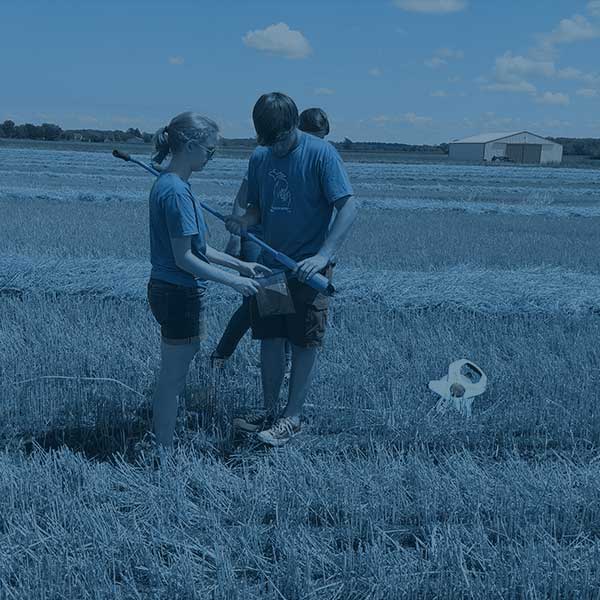 two students taking samples of straw