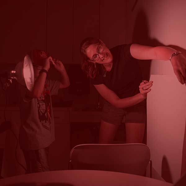 Art student helping a child with their art piece