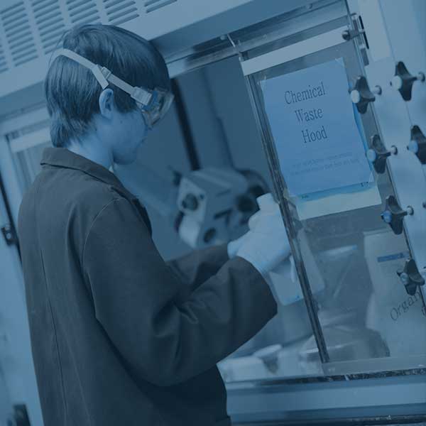 Student pouring chemicals in the waste hood