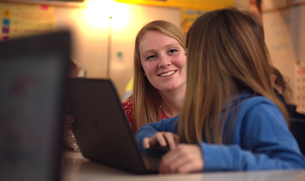 Teacher with student at computer