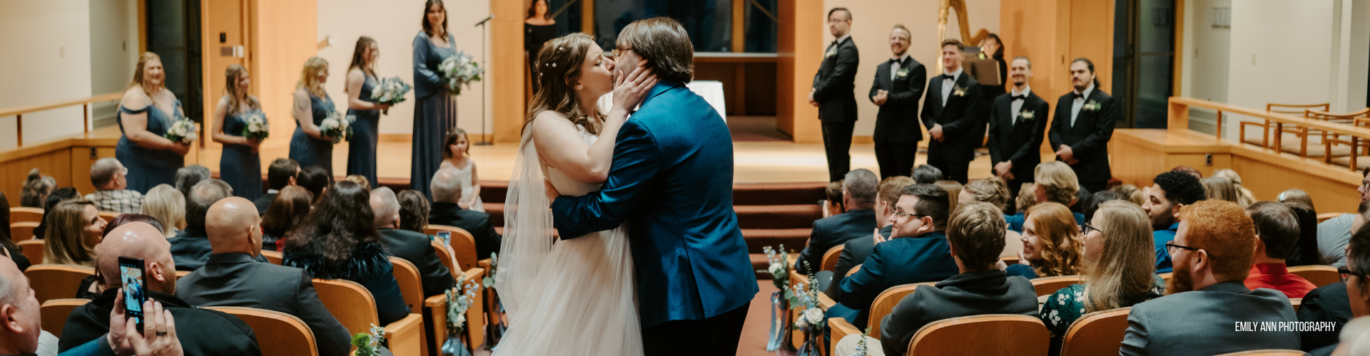 bride and groom kiss in a wedding aisle in front of guests