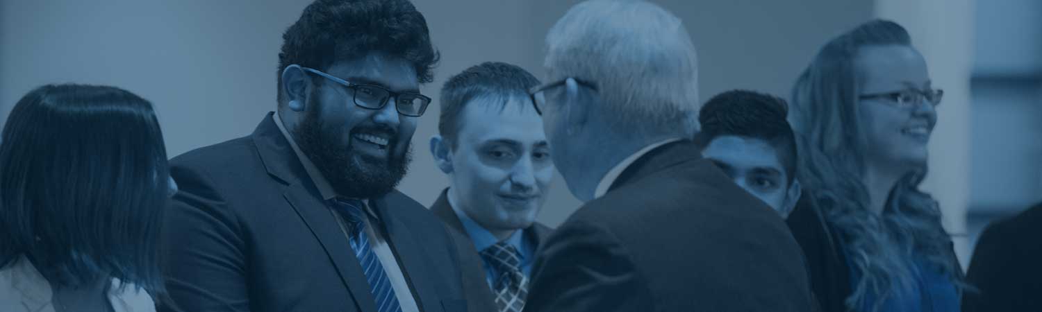 A group of students being greeting by Dr. Bachand