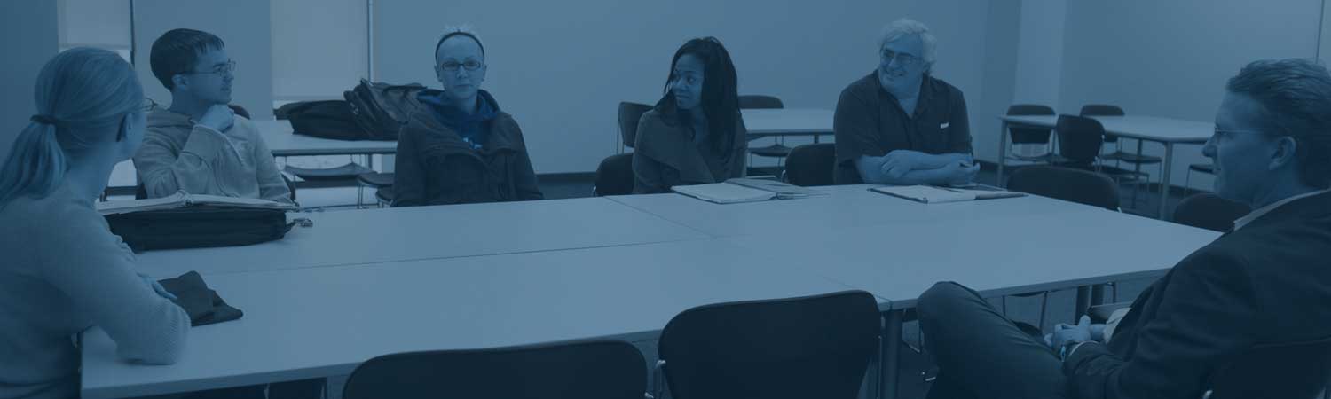 students and faculty discussing things at a table