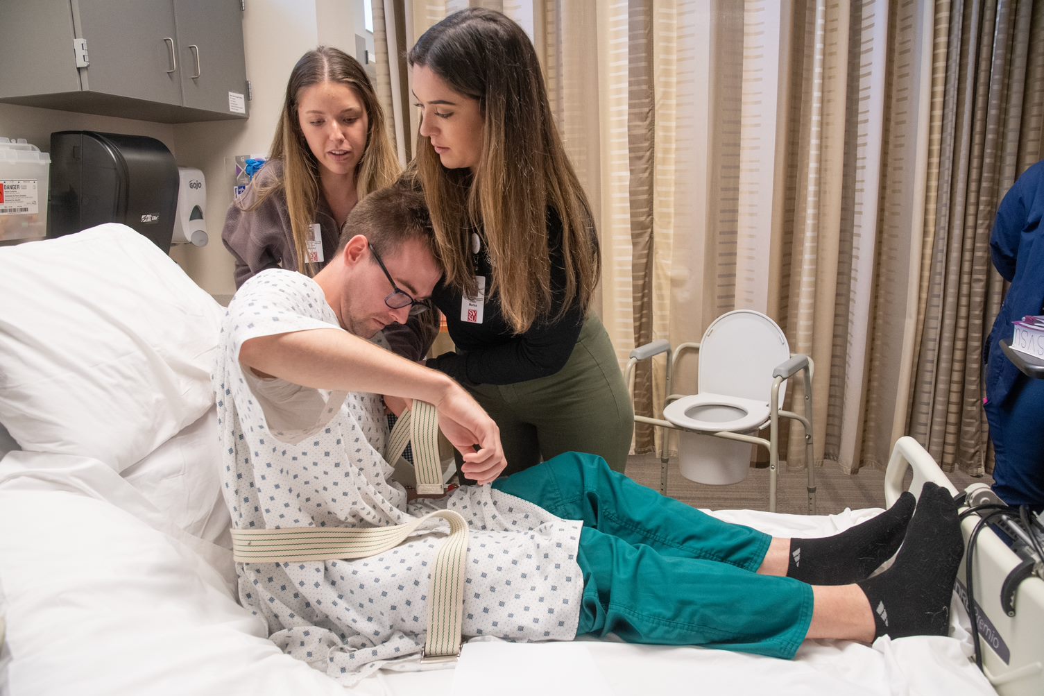 Students learning how to assist patient