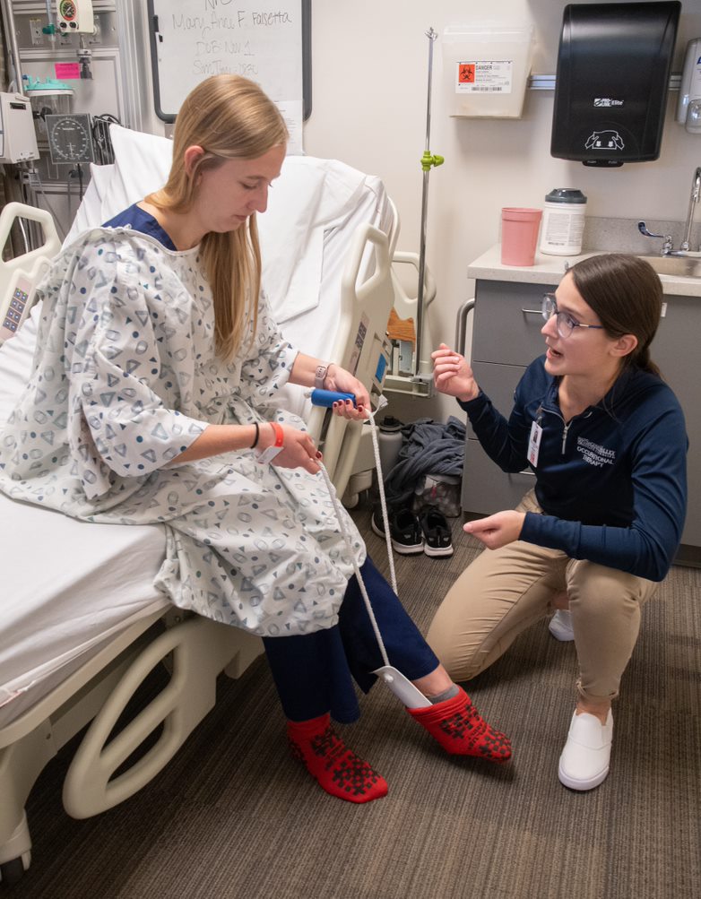 Student learning how to assist patient when dressing