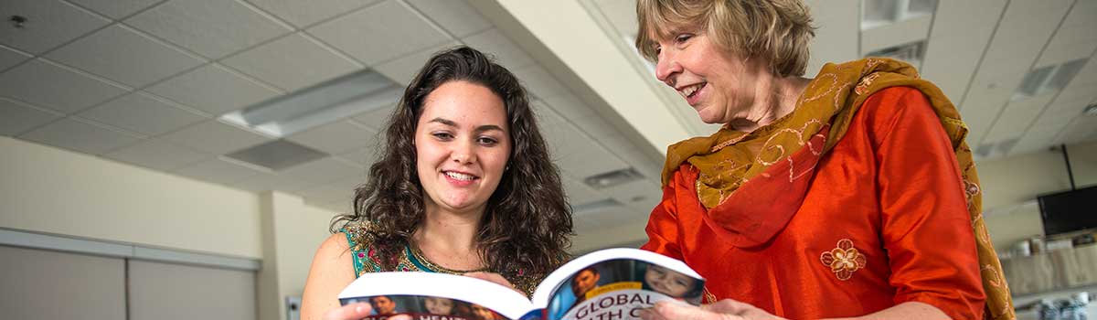 student and faculty reading a book on Ethics research