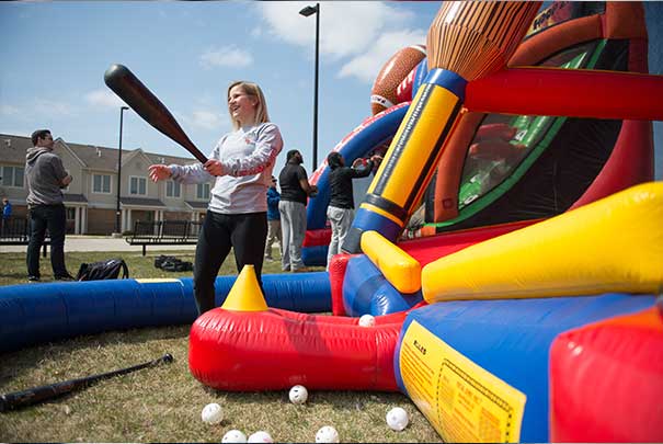student playing baseball with inflatables in front of UVs