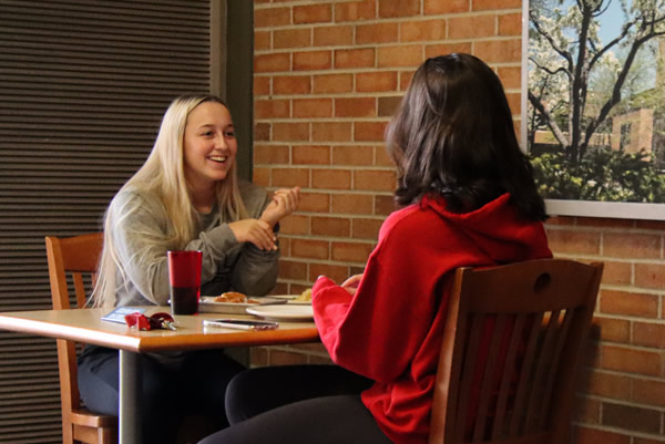 Two SVSU students talk and laugh over drinks at the campus Starbucks.