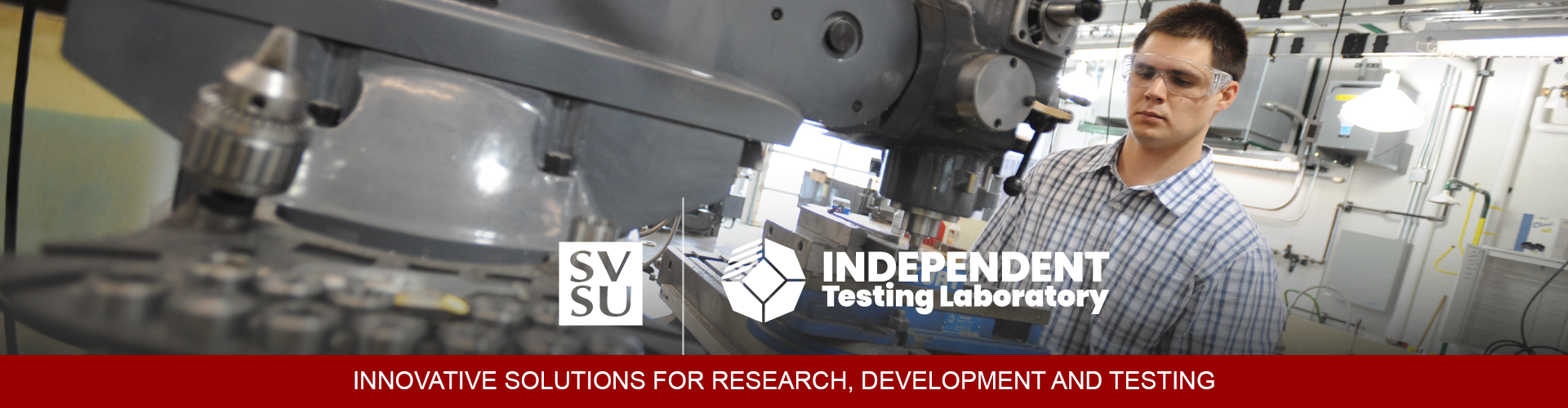 A student in safety goggles, working a drill press