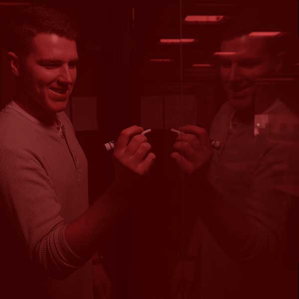 Student doing math problems on a clear dry-erase board