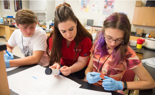 Student helping young kids