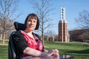Sarah Tennyson, a May 2017 grad, in the courtyard with the bell tower at her back.