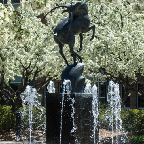 Image of the Leaping Gazelle fountain in the spring with flowering trees