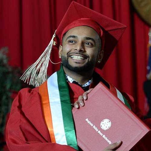Student crossing the stage with diploma