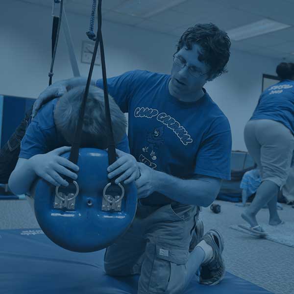 People helping those with autism at a camp