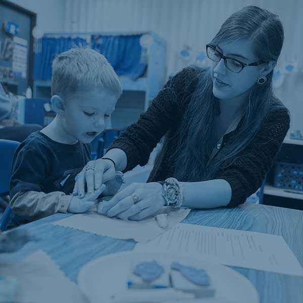 Student teacher working with child in class