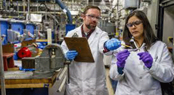 Student and teacher working in a chemical lab.