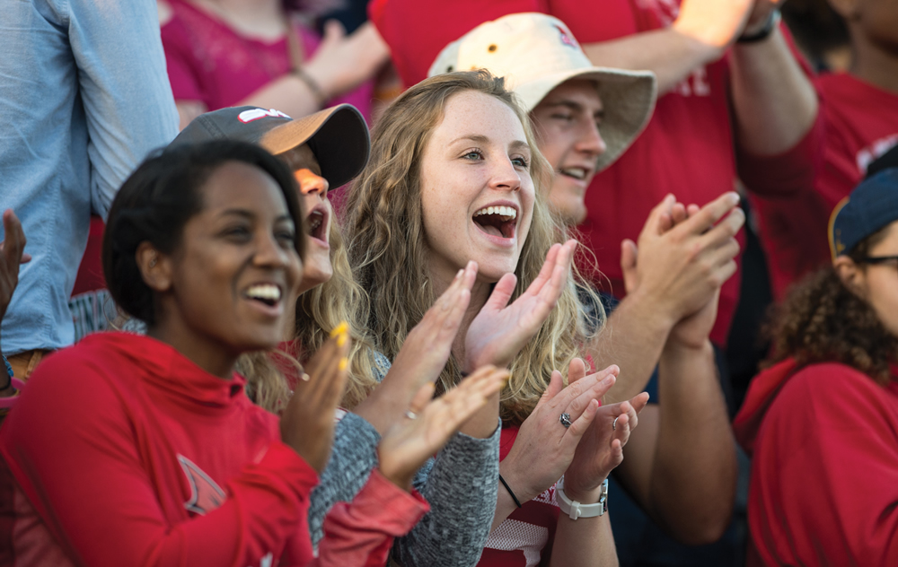 students at football game cheering