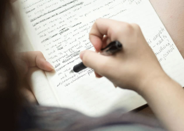 Person with pen writing on letter